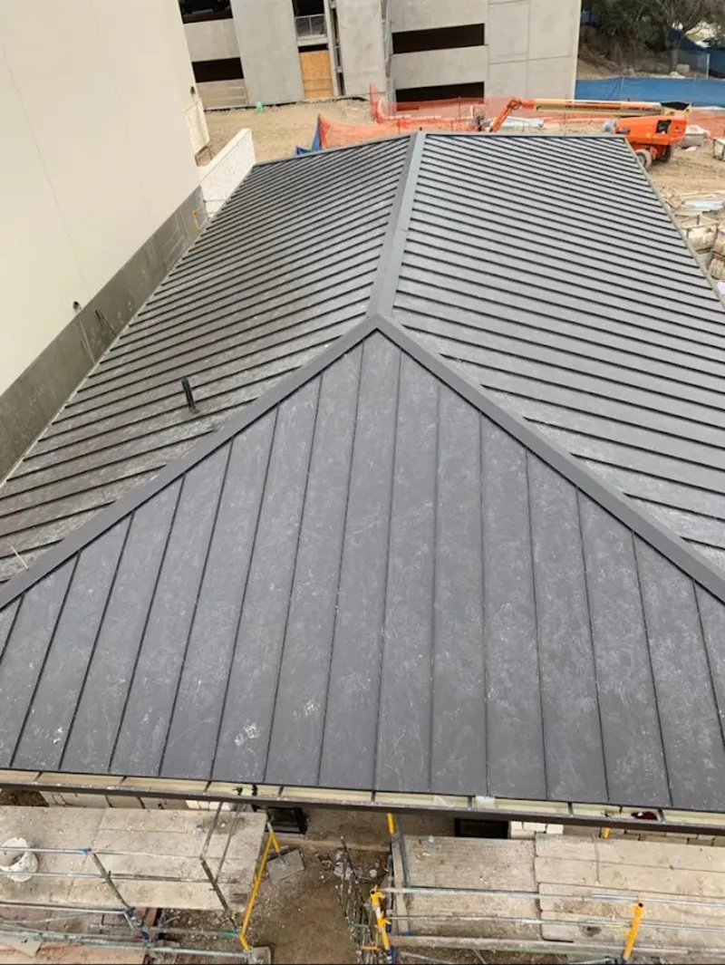 Commercial metal roof construction with crane equipment in West York